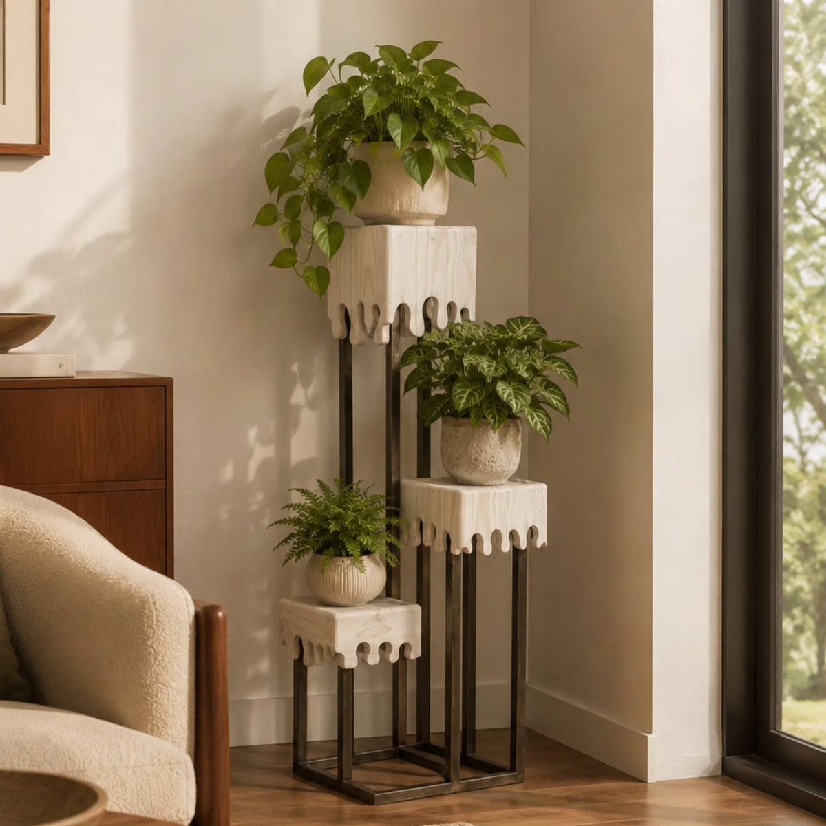 Three green potted plants arranged on a tiered modern metal and stone plant stand indoors.