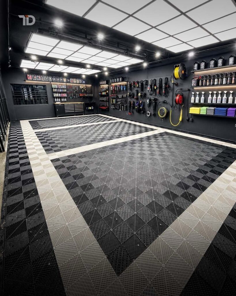 Modern garage interior with black and white patterned flooring and organized tool shelving.