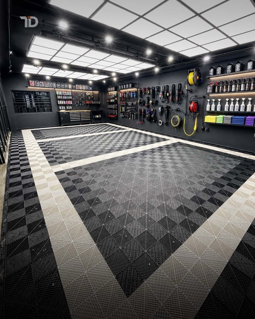 Modern garage interior with black and white patterned flooring and organized tool shelving.