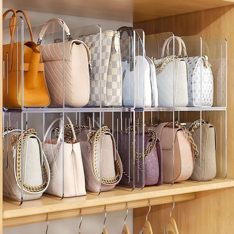 Handbags organized on wooden shelves using clear acrylic dividers to keep them upright.