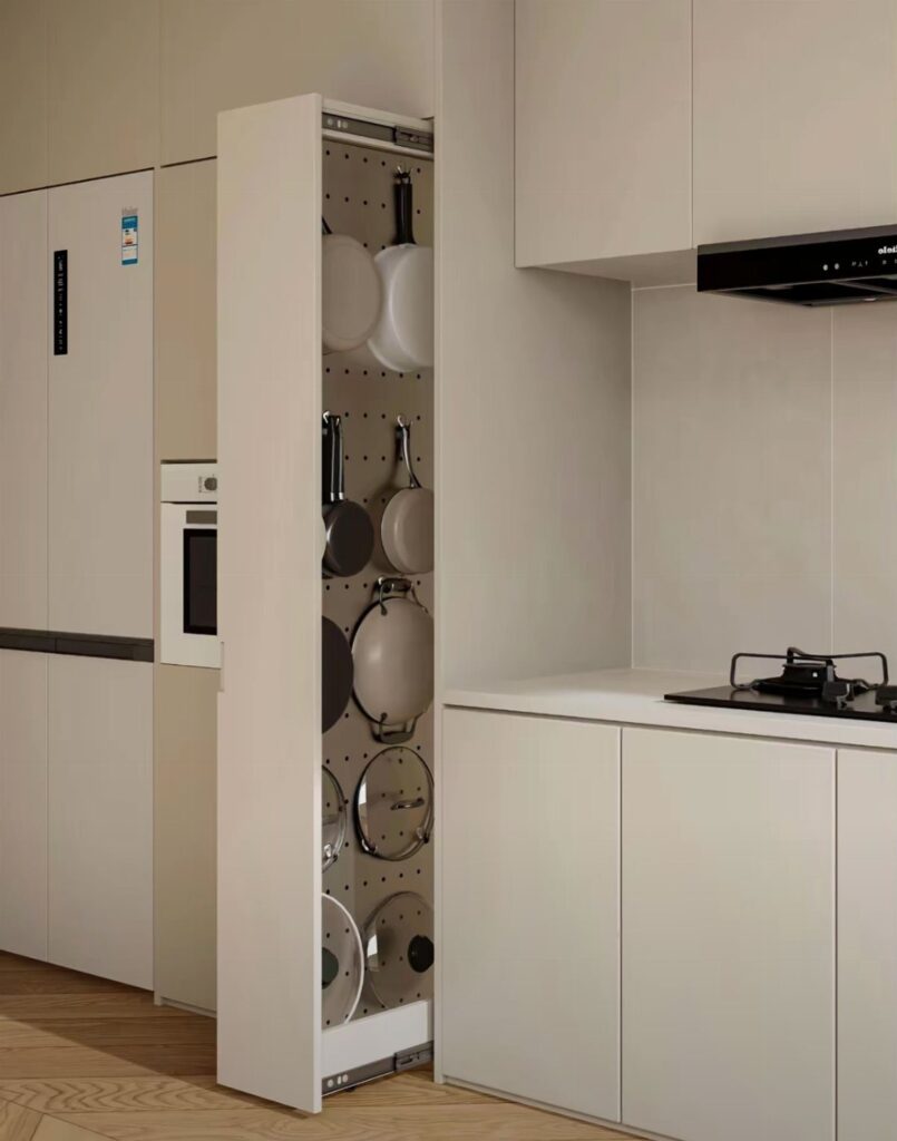 A tall vertical pull-out kitchen cabinet filled with organized pots and pans in a modern kitchen.